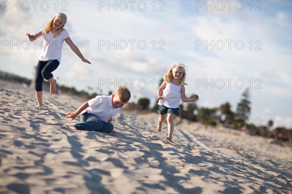 Adorable brother and sisters having fun at the beach one afternoon