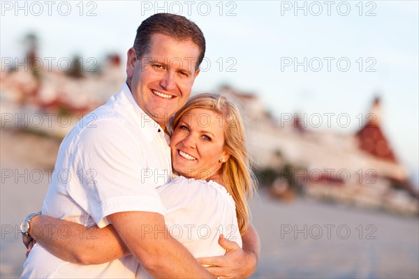 Attractive caucasian couple hugging at the beach in front of the hotel del coronado