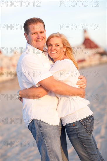 Attractive caucasian couple hugging at the beach in front of the hotel del coronado