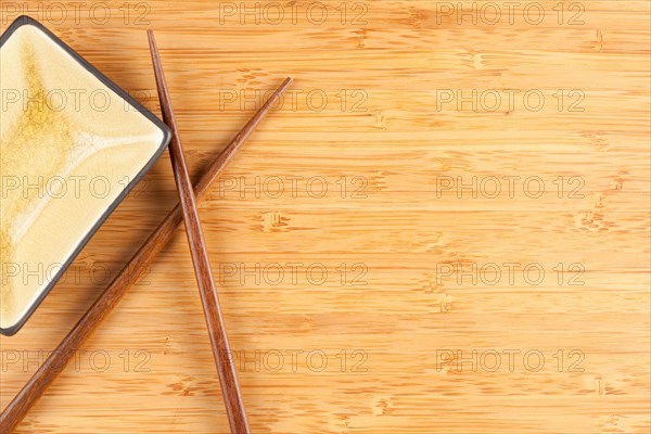 Bamboo textured surface background with chop sticks and bowl and plenty of room for text