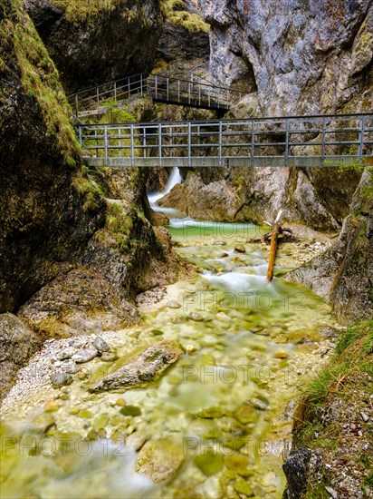 Metal footbridges lead over the torrent of the Almbachklamm