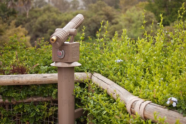 Public coin operated telescope and railing at wilderness overlook