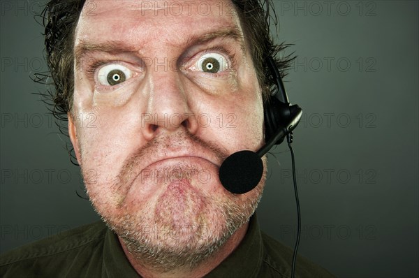 Grumpy frowning customer support man with headset