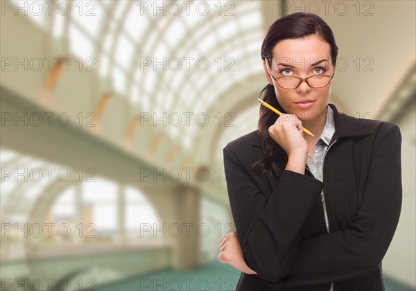 Serious businesswoman standing inside corporate building