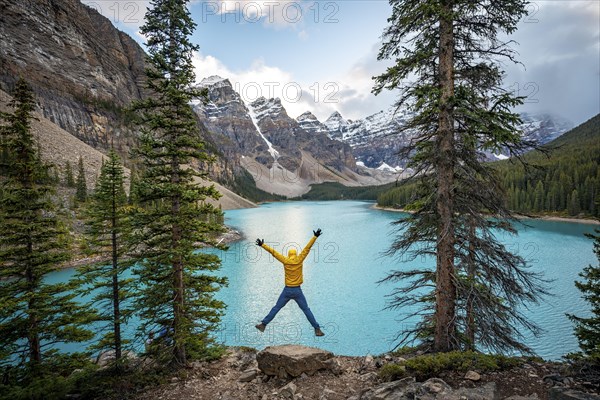 Young man jumps into the air and stretches his arms in the air