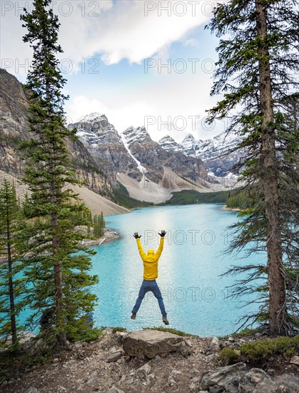 Young man jumps into the air and stretches his arms in the air