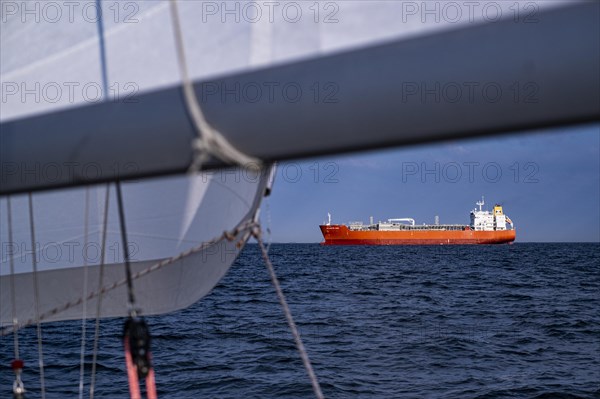 Sailing on the North Sea near Holland with freighter at anchor