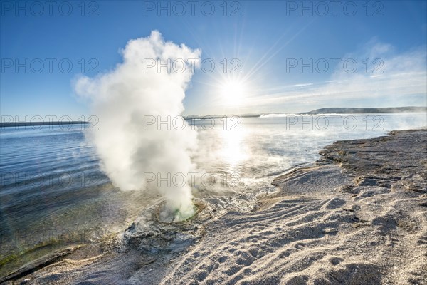 Steaming fumarole at the lake with morning sun