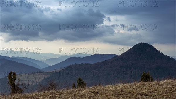 Cloudy sky over wooded hilltops