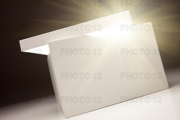 White box with lid revealing something very bright on a grey background
