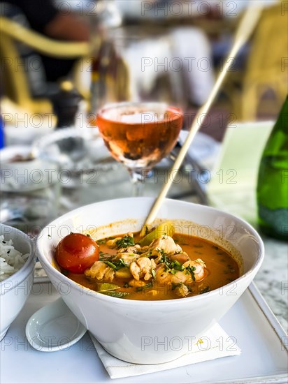 Asian soup in coconut sauce with shrimp and fish with rice