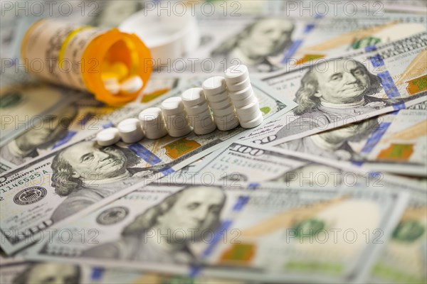 Medicine pills stacked like increasing graph on newly designed U.S. one hundred dollar bills