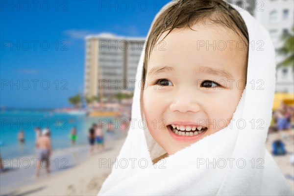 Happy cute mixed-race chinese and caucasian boy on waikiki beach