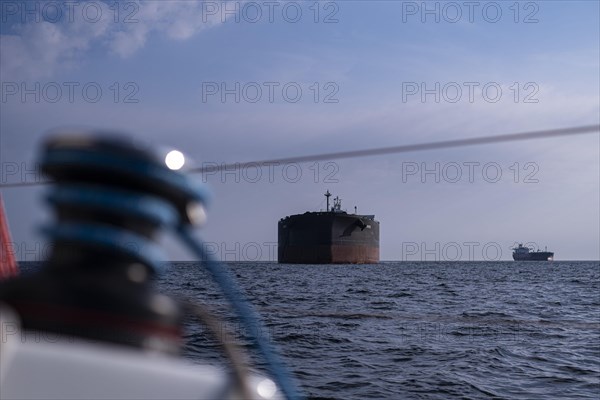 Sailing on the North Sea near Holland with freighter at anchor