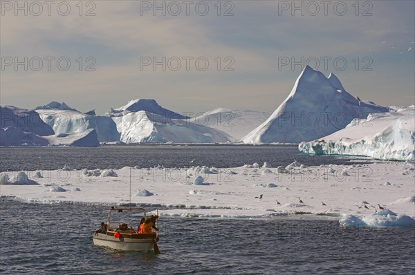 Fishing boat in front of icebergs