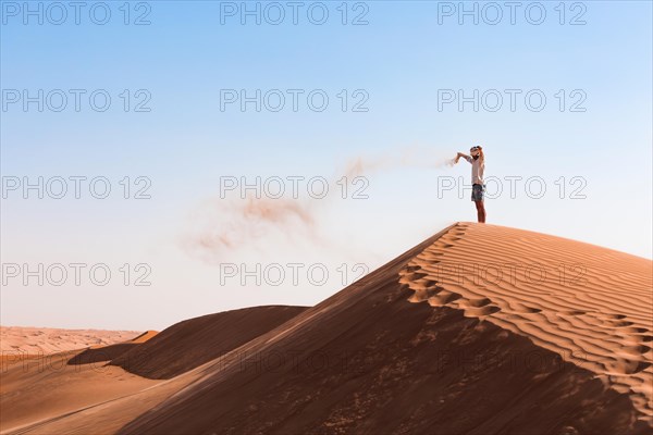 Guy playing with sand in the desert