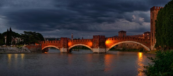 River Adige with the stone bridge Ponte Scaligero at sunset