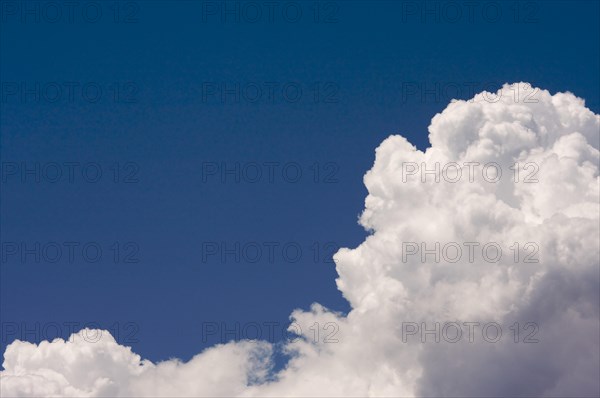 Puffy storm clouds forming on a blue sky