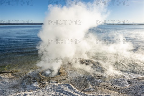 Steaming fumarole at the lake with morning sun