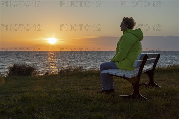 Woman enjoying the sunset on a bench