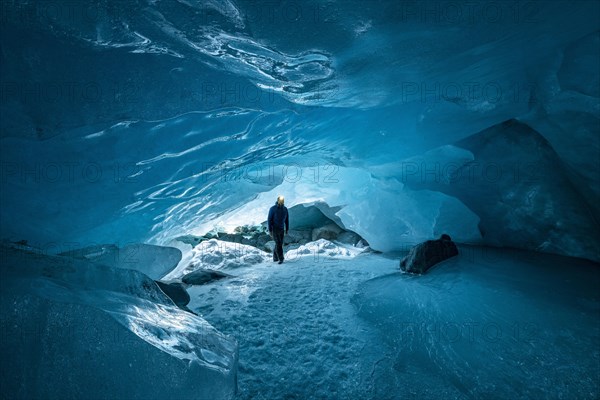 Man with headlamp in glacier cave