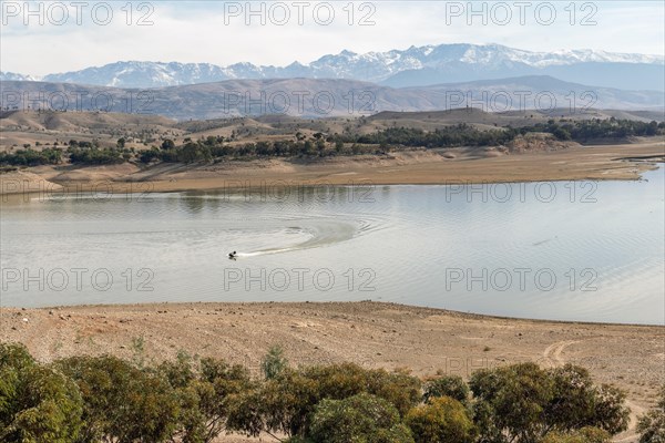 Motorboat on beautiful Takerkoust Lake and Atlas Mountains south from Marrakech