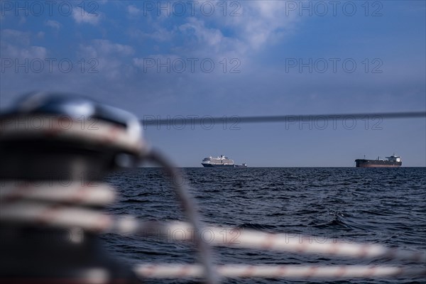 Sailing on the North Sea near Holland with freighter at anchor