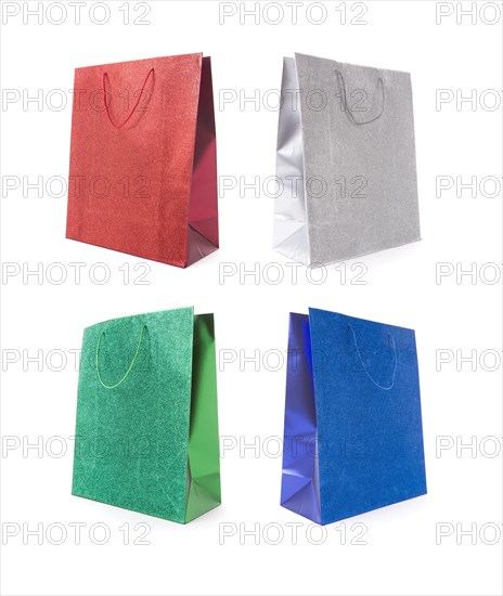 Set of four multicolored glitter gift bags on a white background