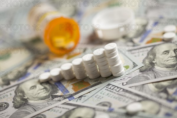Medicine pills stacked like increasing graph on newly designed U.S. one hundred dollar bills