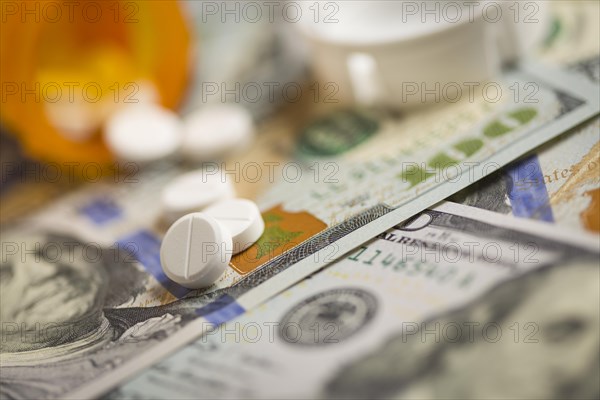 Medicine pills scattered on newly designed U.S. one hundred dollar bills