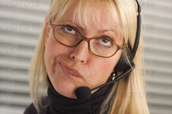 Goofy businesswoman talks on her phone headset