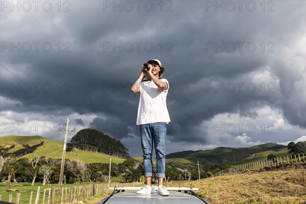 Guy on car roof taking pictures