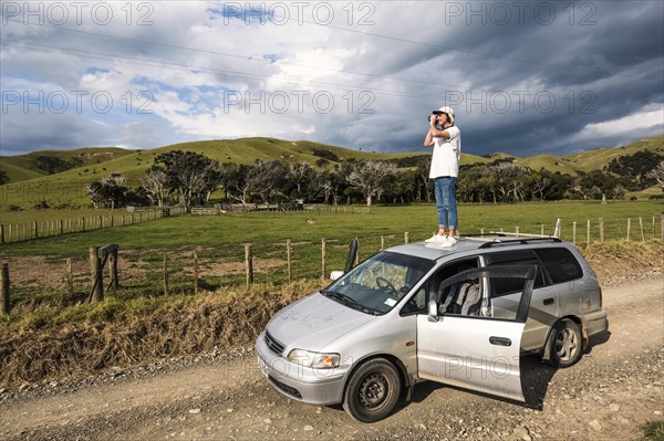 Guy on car roof taking pictures