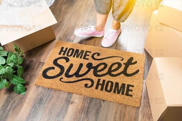 Woman in pink shoes and sweats standing near home sweet home welcome mat