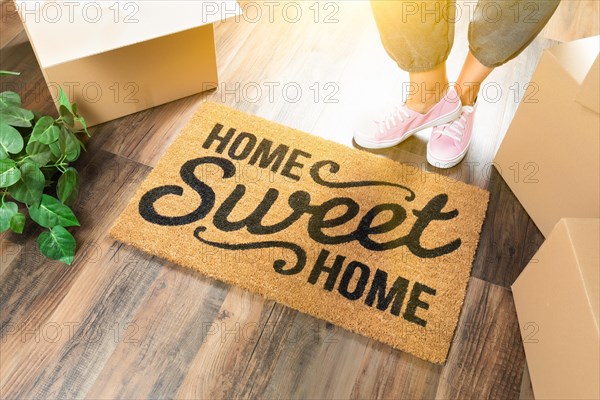 Woman in pink shoes and sweats standing near home sweet home welcome mat