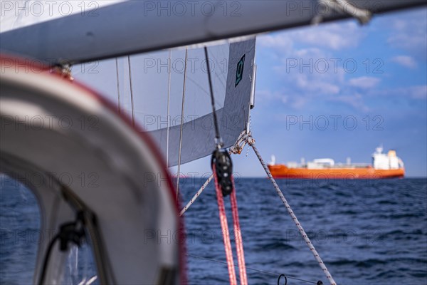 Sailing on the North Sea near Holland with freighter at anchor