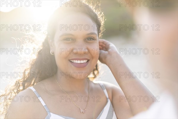 Portrait of a beautiful young woman on the beach by sunset in Algarve