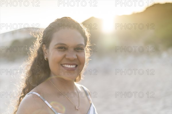 Portrait of a beautiful young woman on the beach by sunset in Algarve