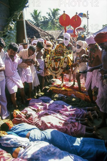 Poojari or priest walking on women in Mahasivaratri festival at poochiyur near Coimbatore