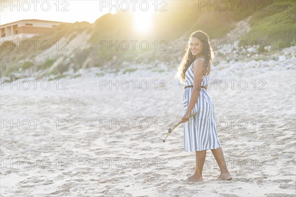 Portrait of a beautiful young woman on the beach by sunset in Algarve