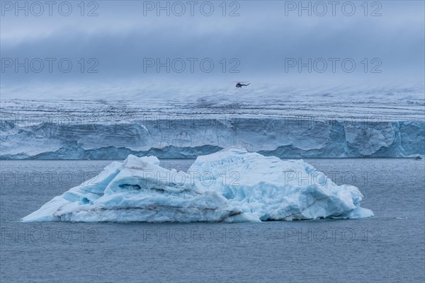 Helicopter flying over a very huge glacier on Mc Clintok or Klintok Island