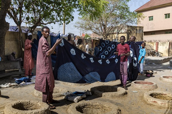 Men presenting indigo clothes at the dyeing pits