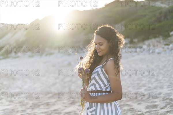 Portrait of a beautiful young woman on the beach by sunset in Algarve