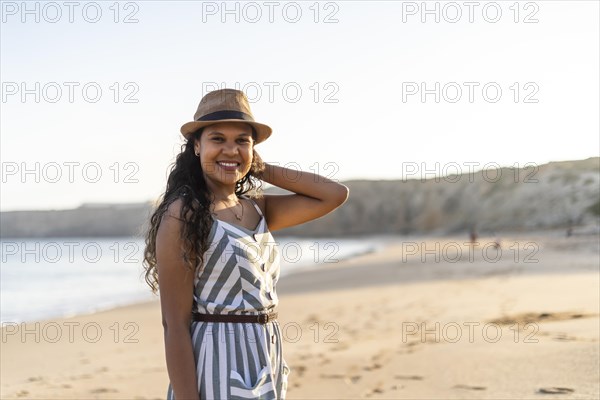 Portrait of a beautiful young woman on the beach by sunset in Algarve