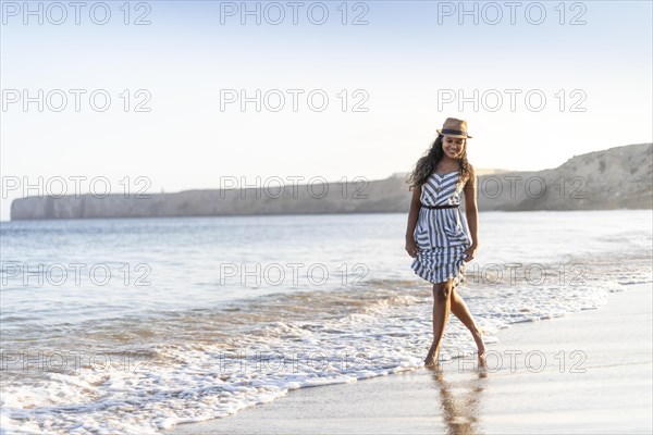 Portrait of a beautiful young woman on the beach by sunset in Algarve