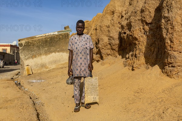 Young boy with the quran coming out of a medressa