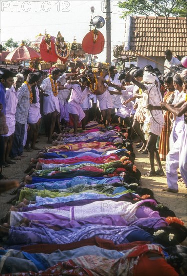 Poojari or priest walking on women in Mahasivaratri festival at poochiyur near Coimbatore