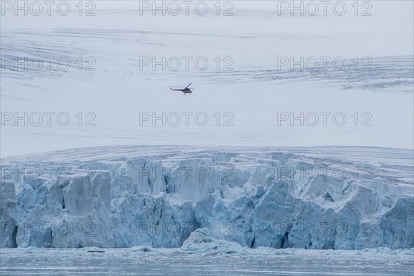 Helicopter flying over the giant icefield of Alexandra Land