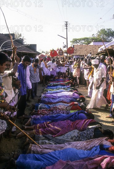 Poojari or priest walking on women in Mahasivaratri festival at poochiyur near Coimbatore