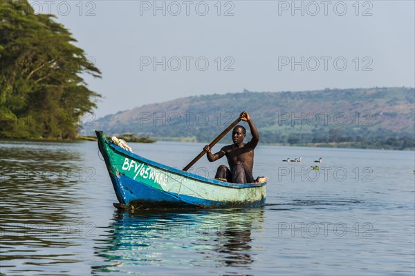 Local fisherman in a dugout canoe in Jinja